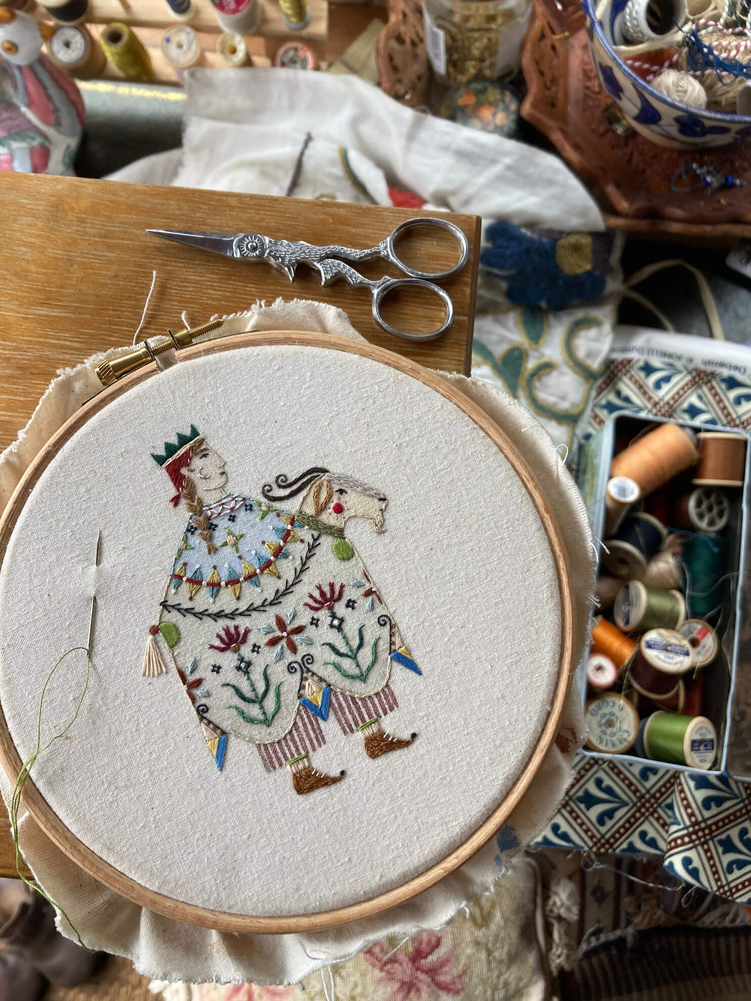 Folk inspired embroidered figure on hoop inside the bohemian studio of British illustrator and embroiderer Megan Ivy Griffiths