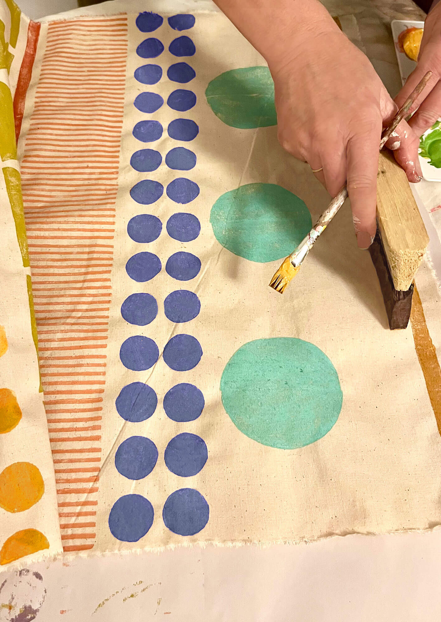 ai·no·ah founder Noa Alvarez block printing material with colourful circles and stripes