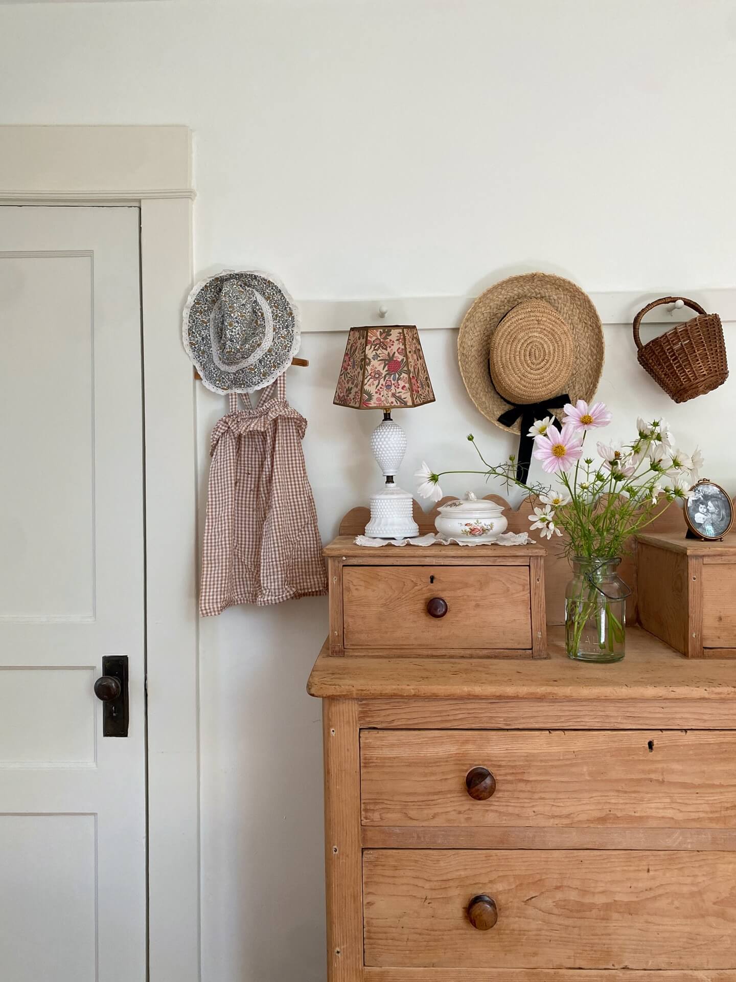 vintage wooden drawers and a peg rail with cute kids items hanging. 