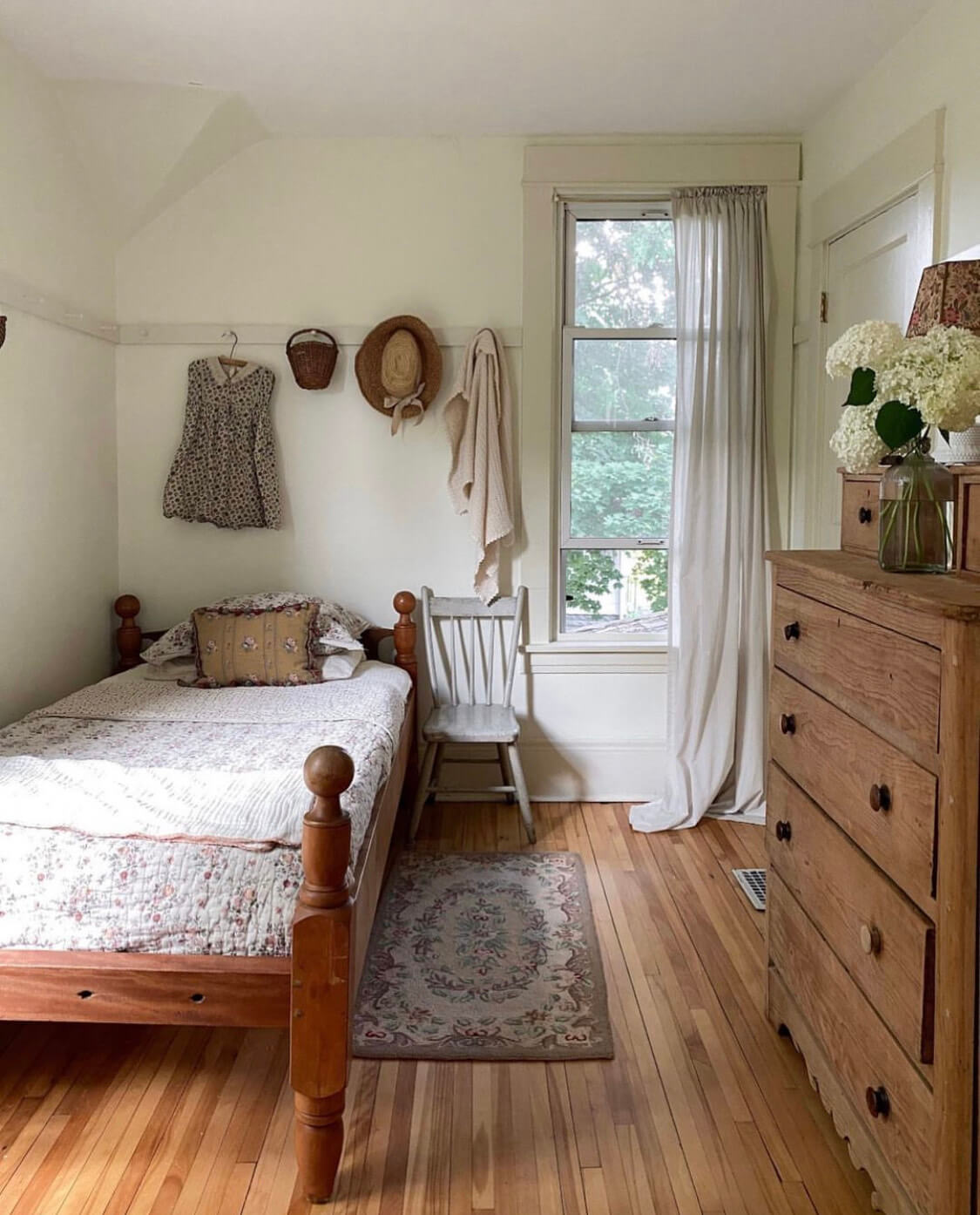 Child's bedroom decorated in a rustic style with bare wooden furniture and vintage finds. 