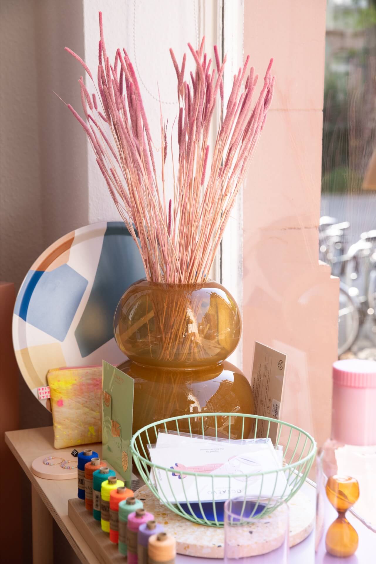 Glass vase and dried pink grass inside lifestyle concept store Studio Bloom