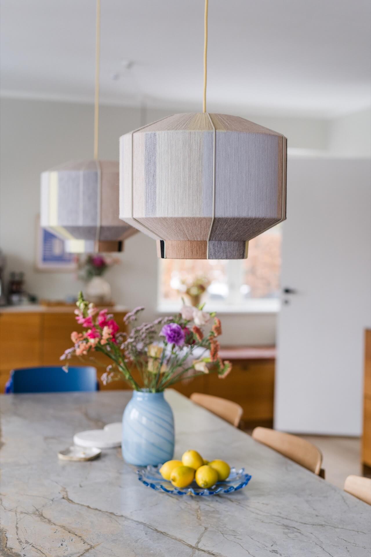Pastel coloured lamp shades over a dining table in a Danish home - featured in 91 Magazine Volume 17 (out in April 2024)