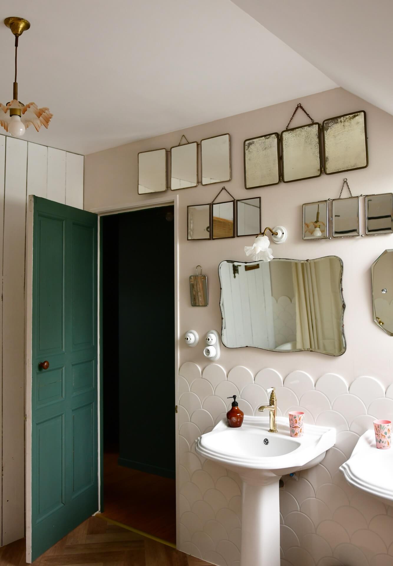 Bathroom with a wall of old vintage mirrors