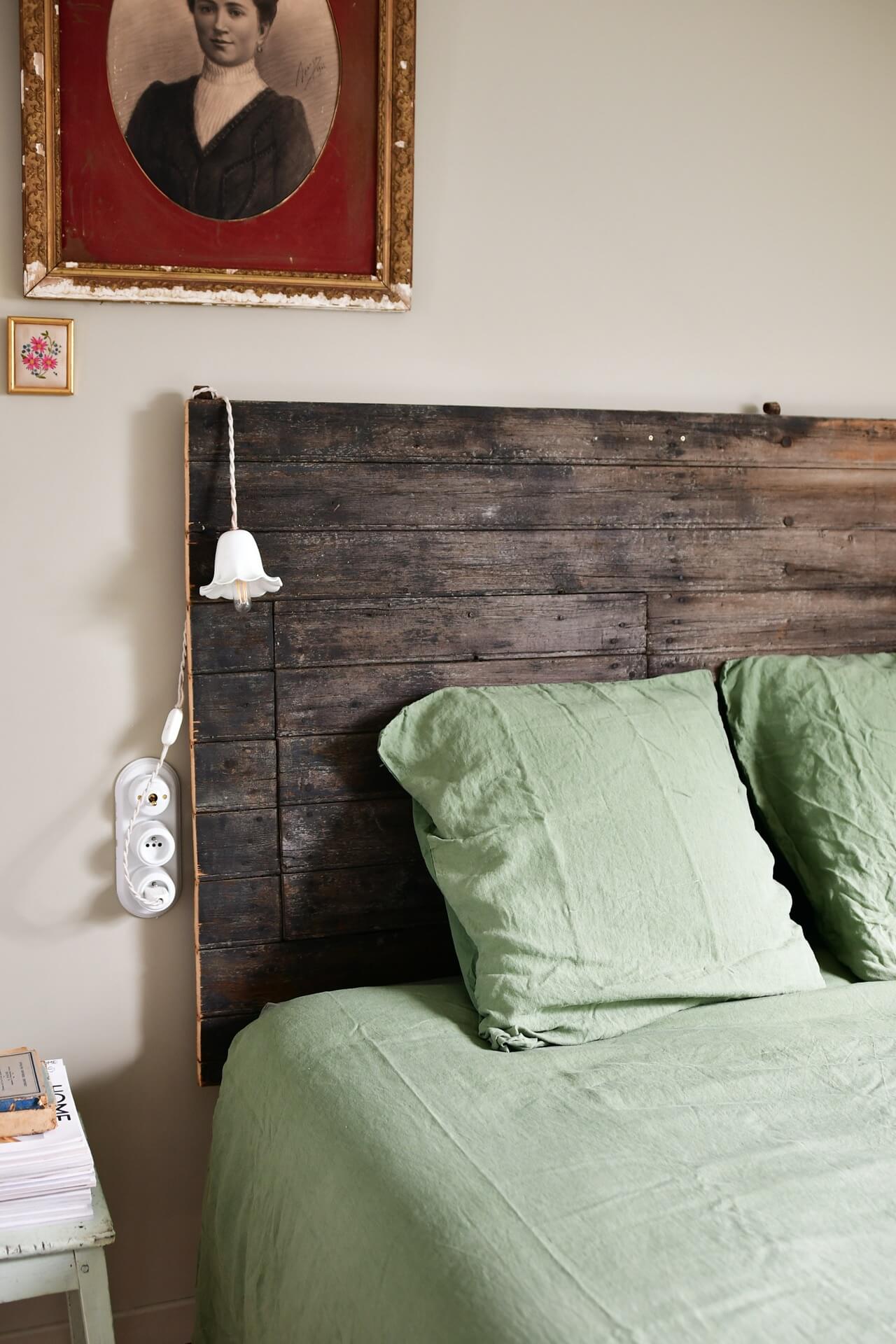Bed headboard made from reclaimed wood and vintage details decorating the space