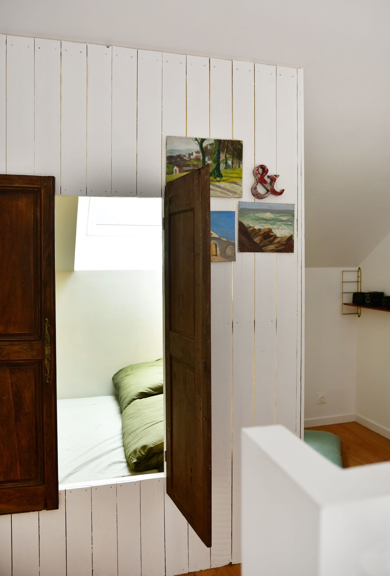 a bed nook hidden behind panelled walls and old vintage doors. 