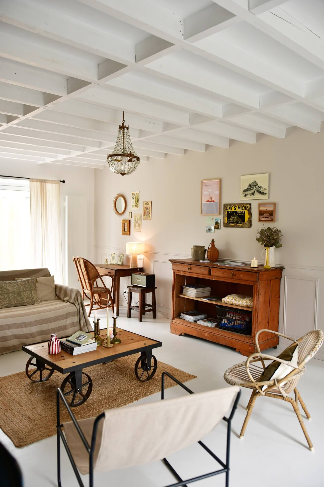 an airy living room in a French barn conversion with vintage furniture and other vintage finds decorating the space. 