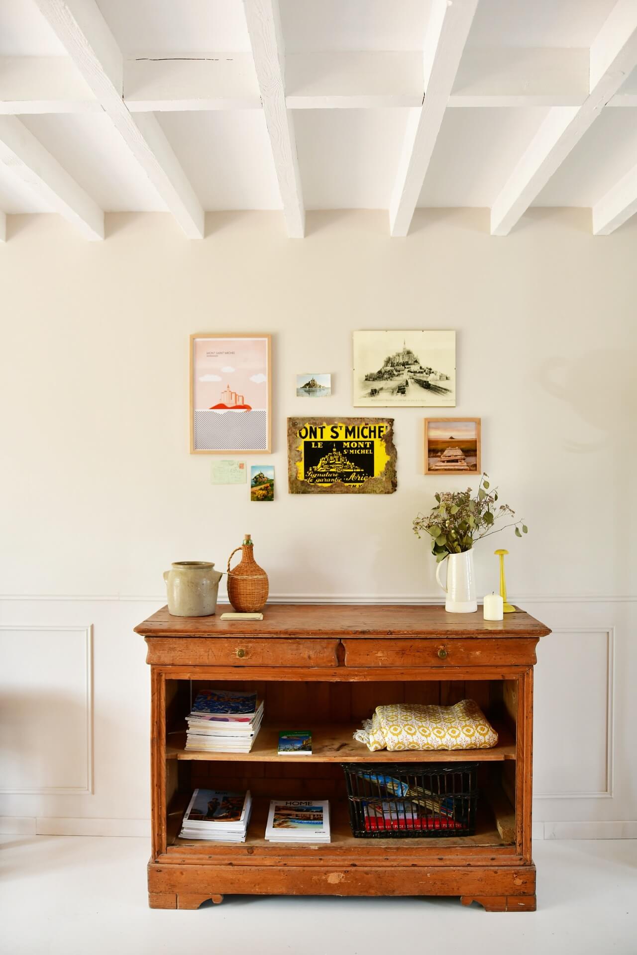 old wooden furniture in a modernised home decorated with a mix of vintage pictures and contemporary art. 